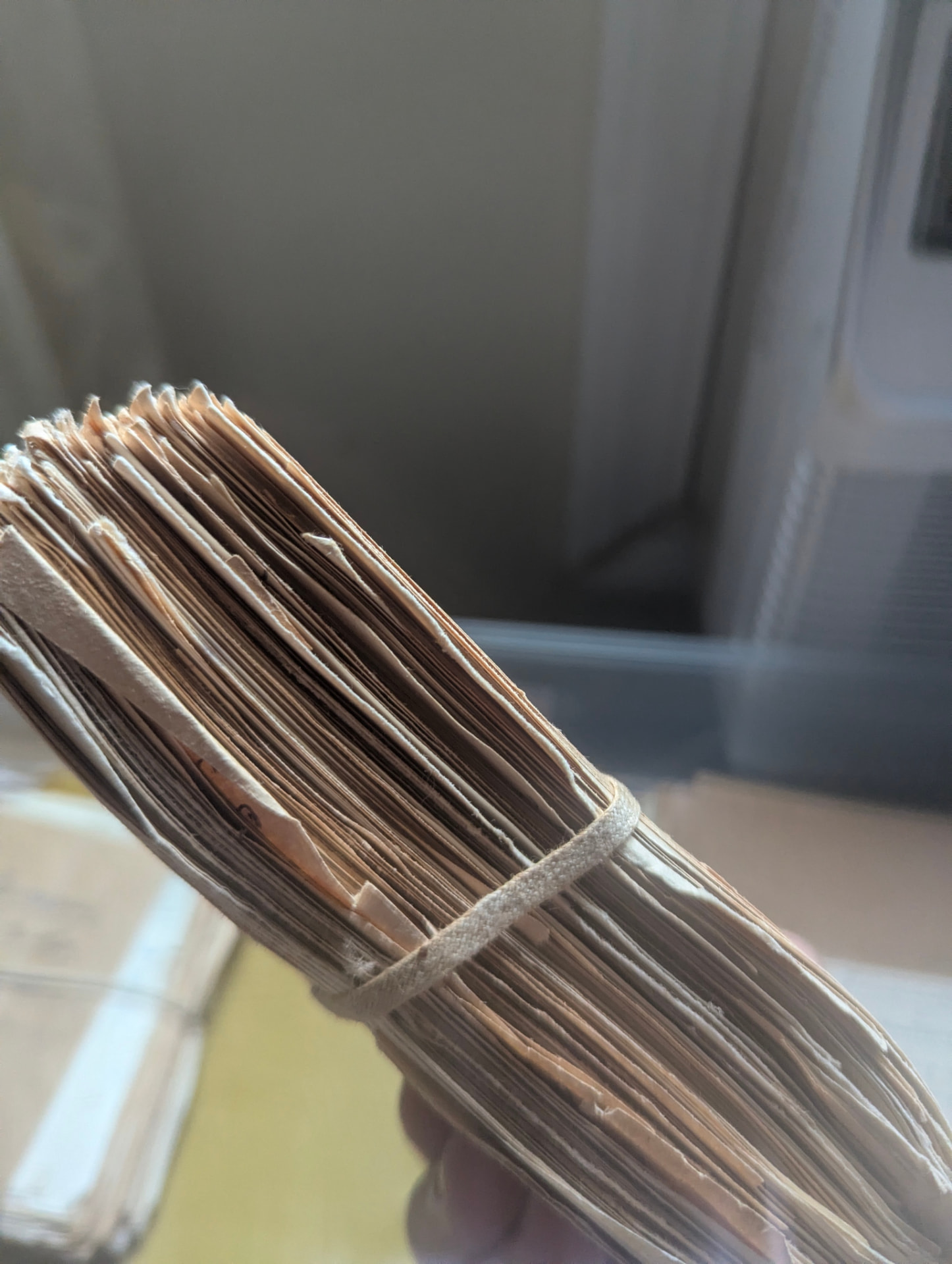Untied but unprocessed: a bundle of cards still bound in cotton tape, as it was left.